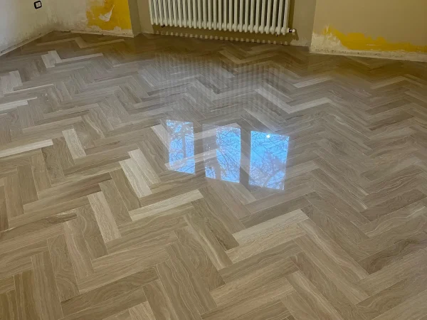 Pavimento effetto legno a spina di pesce trattato e lucidato a Vercelli da Palumbo Pavimenti